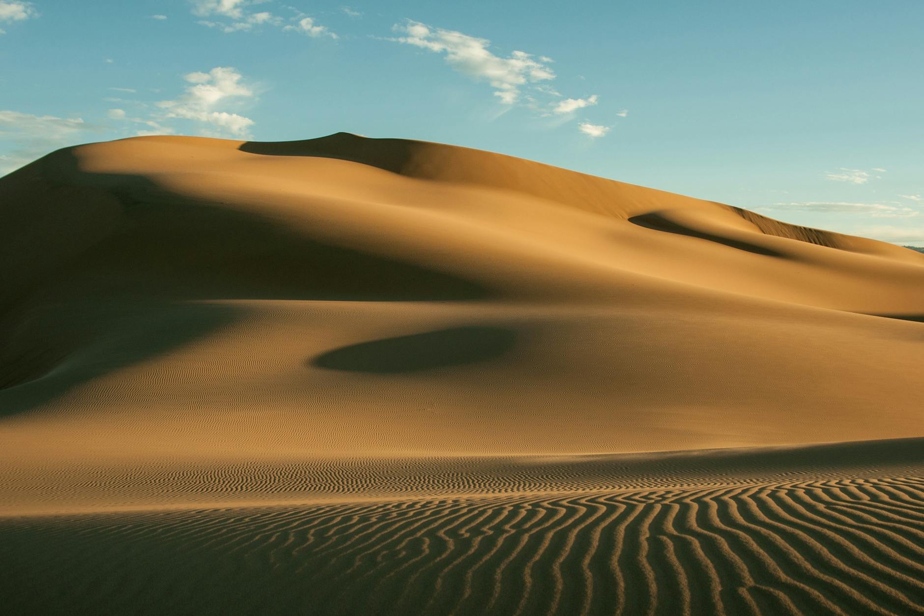 A stunning image of vast sand dunes under a clear blue sky, showcasing the beauty of the desert landscape. A stunning image of vast sand dunes under a clear blue sky, showcasing the beauty of the desert landscape.