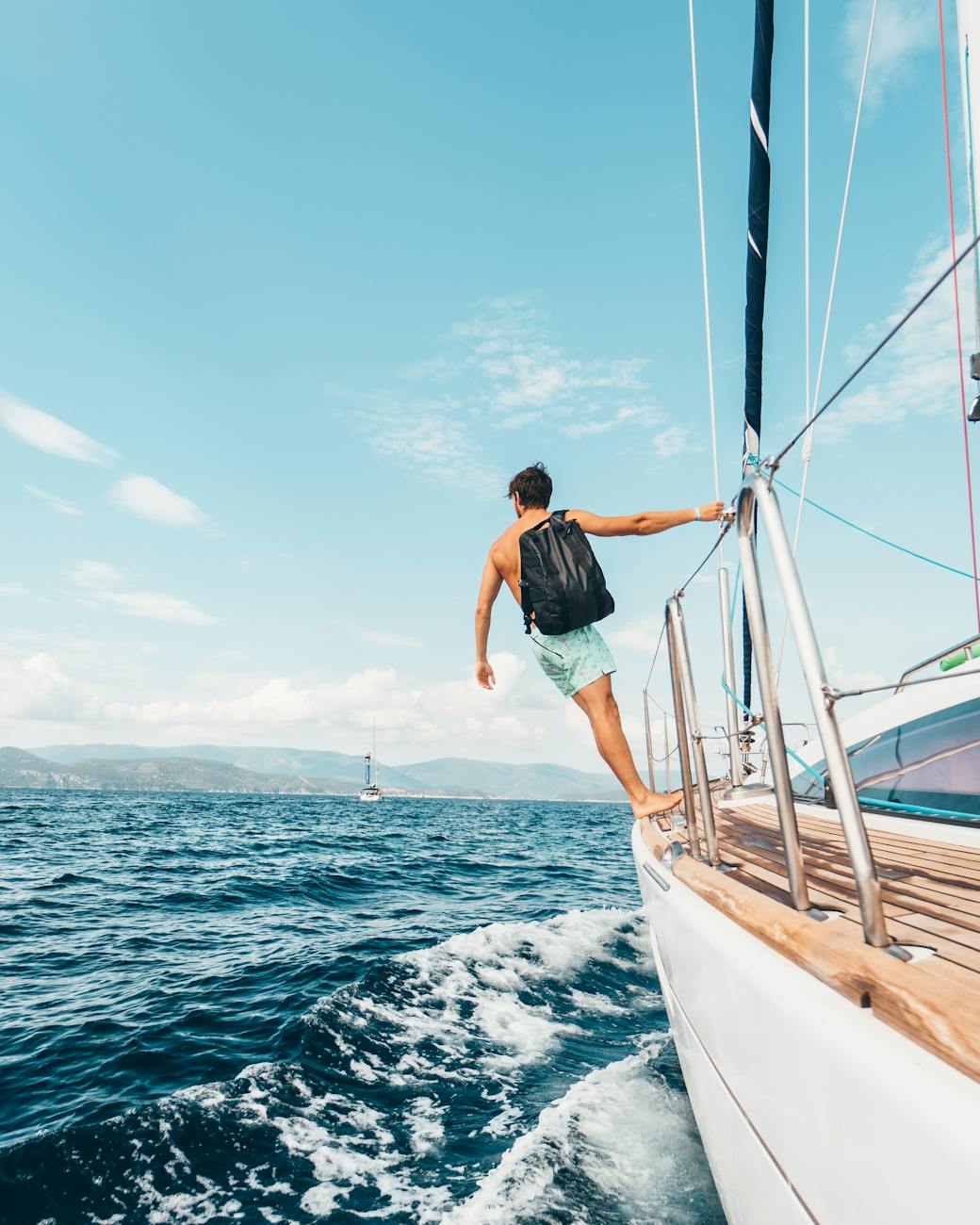 Man sailing in vibrant Greek waters, depicting freedom and adventure under clear skies. Man sailing in vibrant Greek waters, depicting freedom and adventure under clear skies.