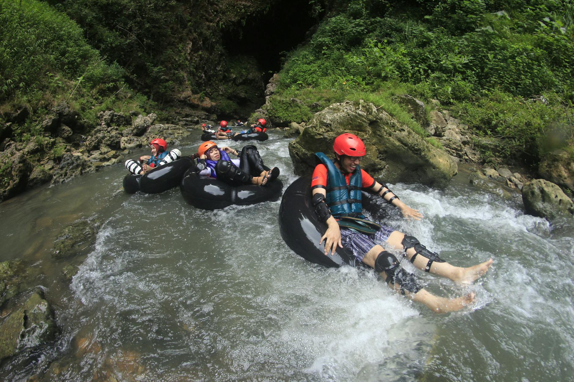 Thrill-seekers enjoy a tubing adventure through a scenic river in Semanu, Indonesia. Thrill-seekers enjoy a tubing adventure through a scenic river in Semanu, Indonesia.
