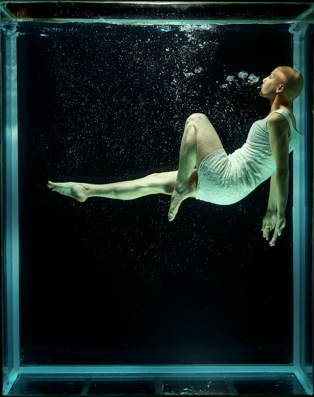 Artistic underwater shot of a woman floating gracefully in a…
