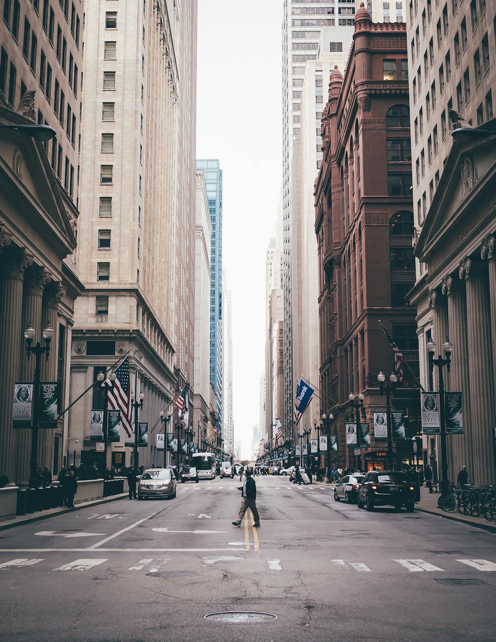 Classic view of a pedestrian crossing a bustling Chicago street lined with skyscrapers.