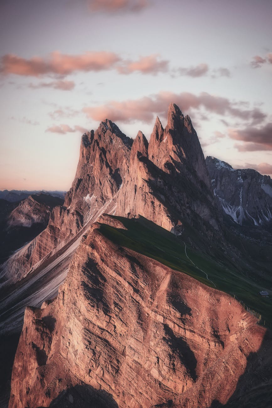Breathtaking view of the sharp peaks of Seceda in the Dolomites during twilight, highlighting natural beauty. Breathtaking view of the sharp peaks of Seceda in the Dolomites during twilight, highlighting natural beauty.