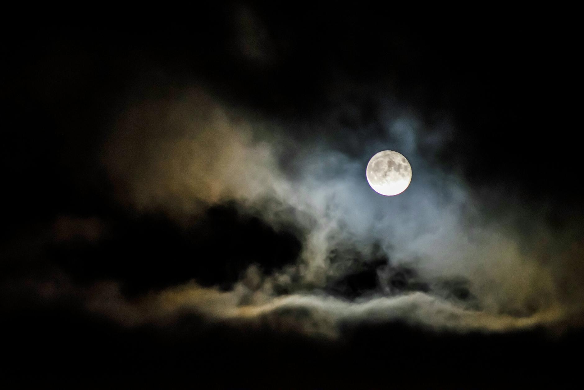 A full moon illuminates the night sky, shrouded by eerie…