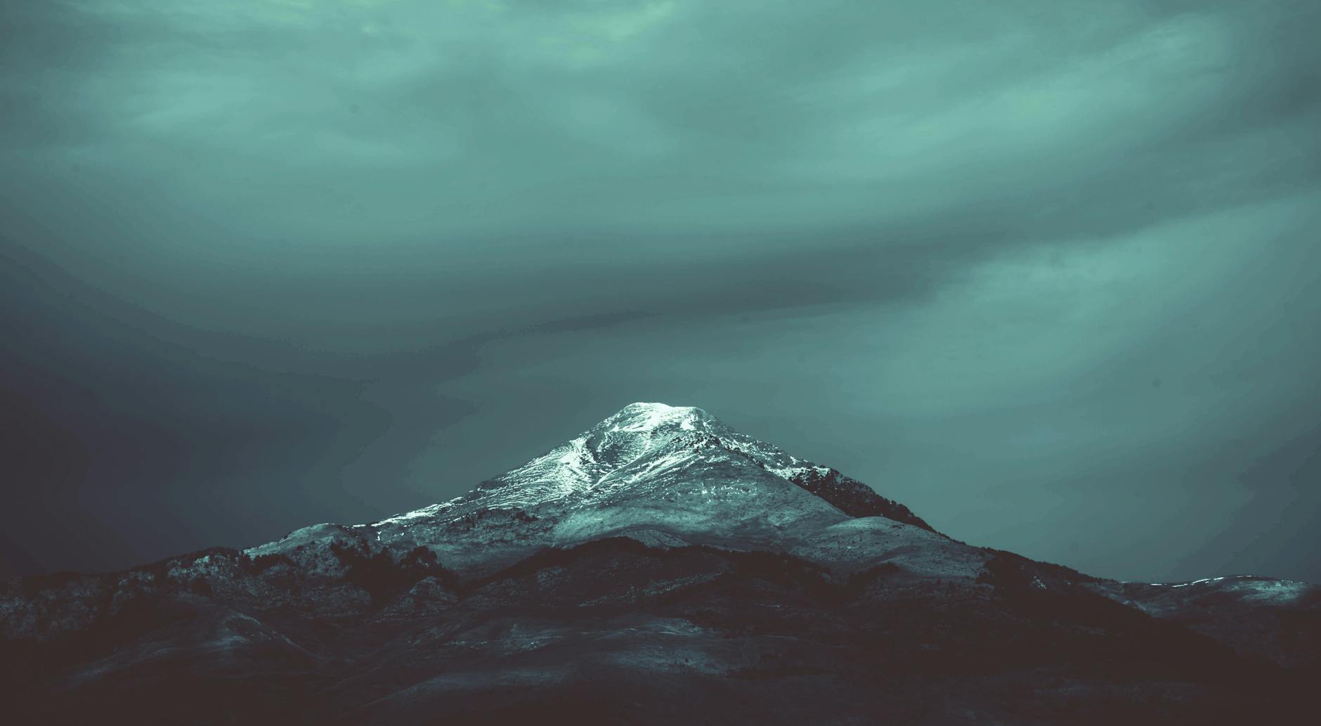 A dramatic snow-capped mountain peak in Algeria set against a moody sky, perfect for winter landscapes. A dramatic snow-capped mountain peak in Algeria set against a moody sky, perfect for winter landscapes.