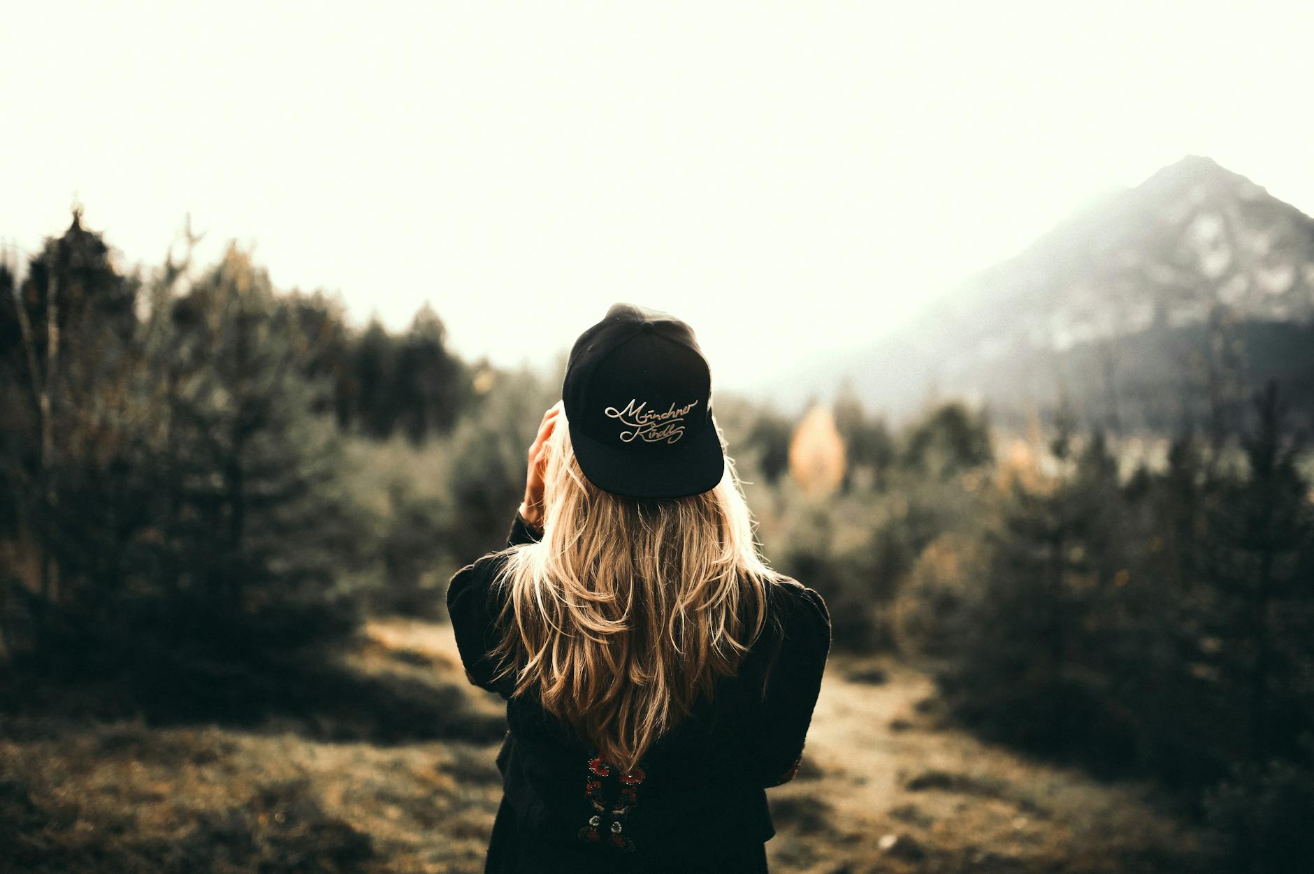 A woman in black cap and sweater enjoys a mountain view, embracing outdoor adventure. A woman in black cap and sweater enjoys a mountain view, embracing outdoor adventure.