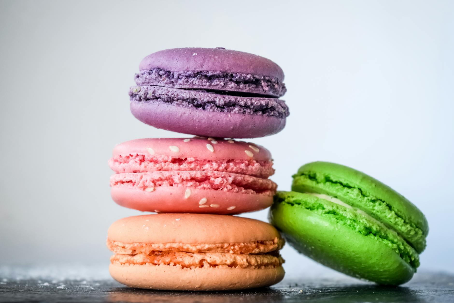 A vibrant stack of colorful macarons with sesame seeds, perfect…