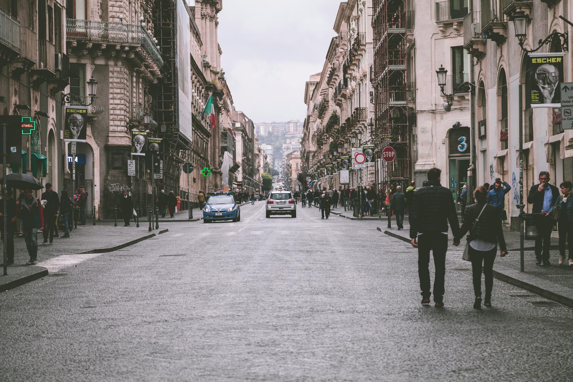 A bustling European street scene with architecture and a couple holding hands. A bustling European street scene with architecture and a couple holding hands.
