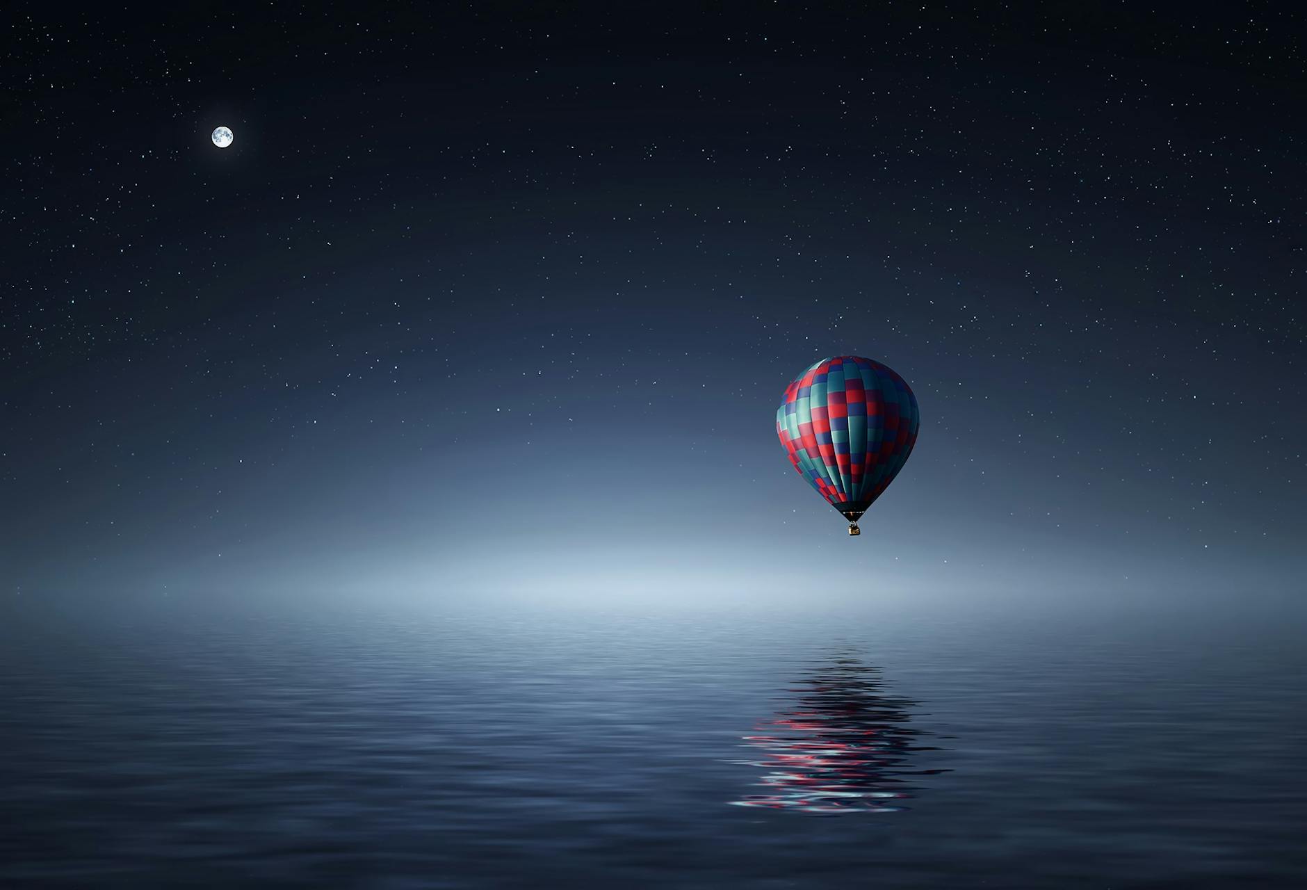 A serene hot air balloon floating over the ocean under a starry night sky. A serene hot air balloon floating over the ocean under a starry night sky.