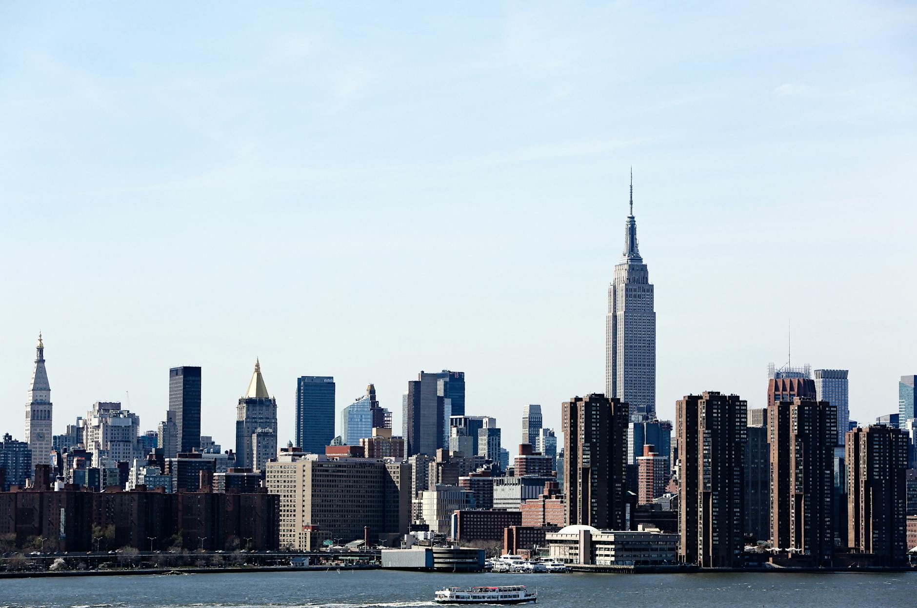 A stunning view of the New York City skyline featuring the iconic Empire State Building under a clear blue sky. A stunning view of the New York City skyline featuring the iconic Empire State Building under a clear blue sky.