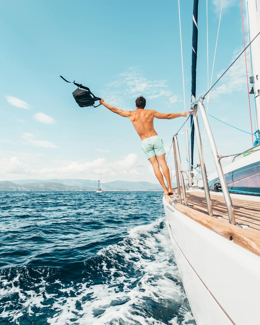 Man enjoying freedom by jumping into the ocean from a sailboat in Greece. Man enjoying freedom by jumping into the ocean from a sailboat in Greece.