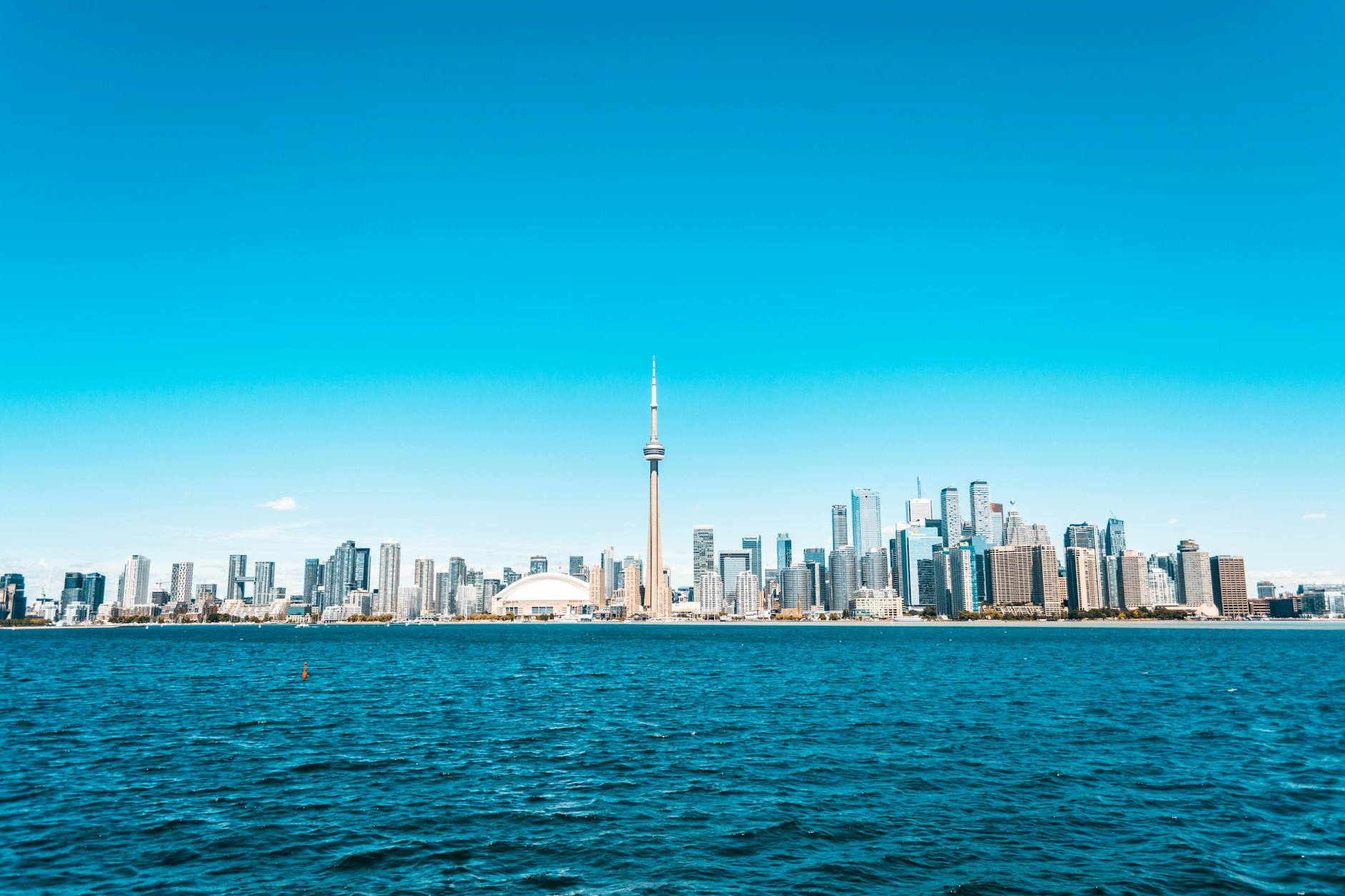 Beautiful view of Toronto skyline featuring the iconic CN Tower and vibrant blue waterfront.
