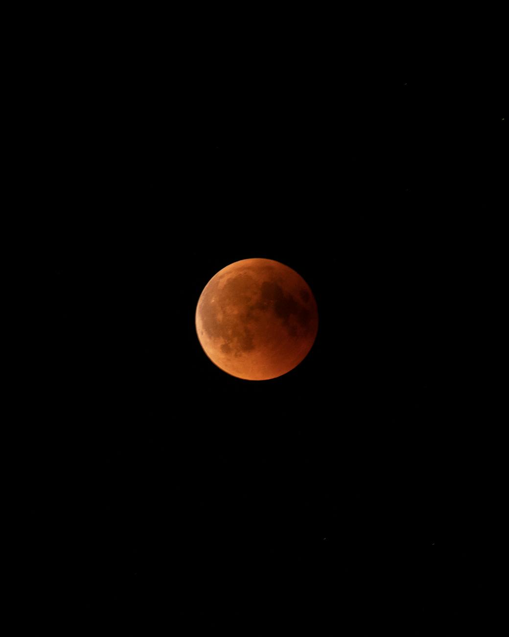 Captivating view of a blood moon during a lunar eclipse at night, showcasing the moon’s surface features.