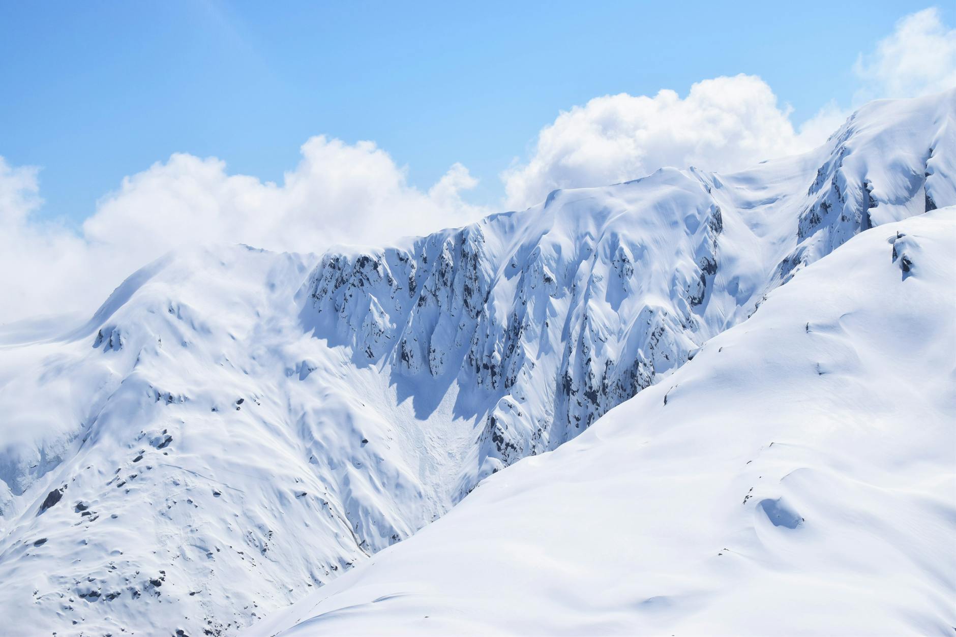 Stunning snowy mountains under a bright blue sky in Gimmerburn, New Zealand.