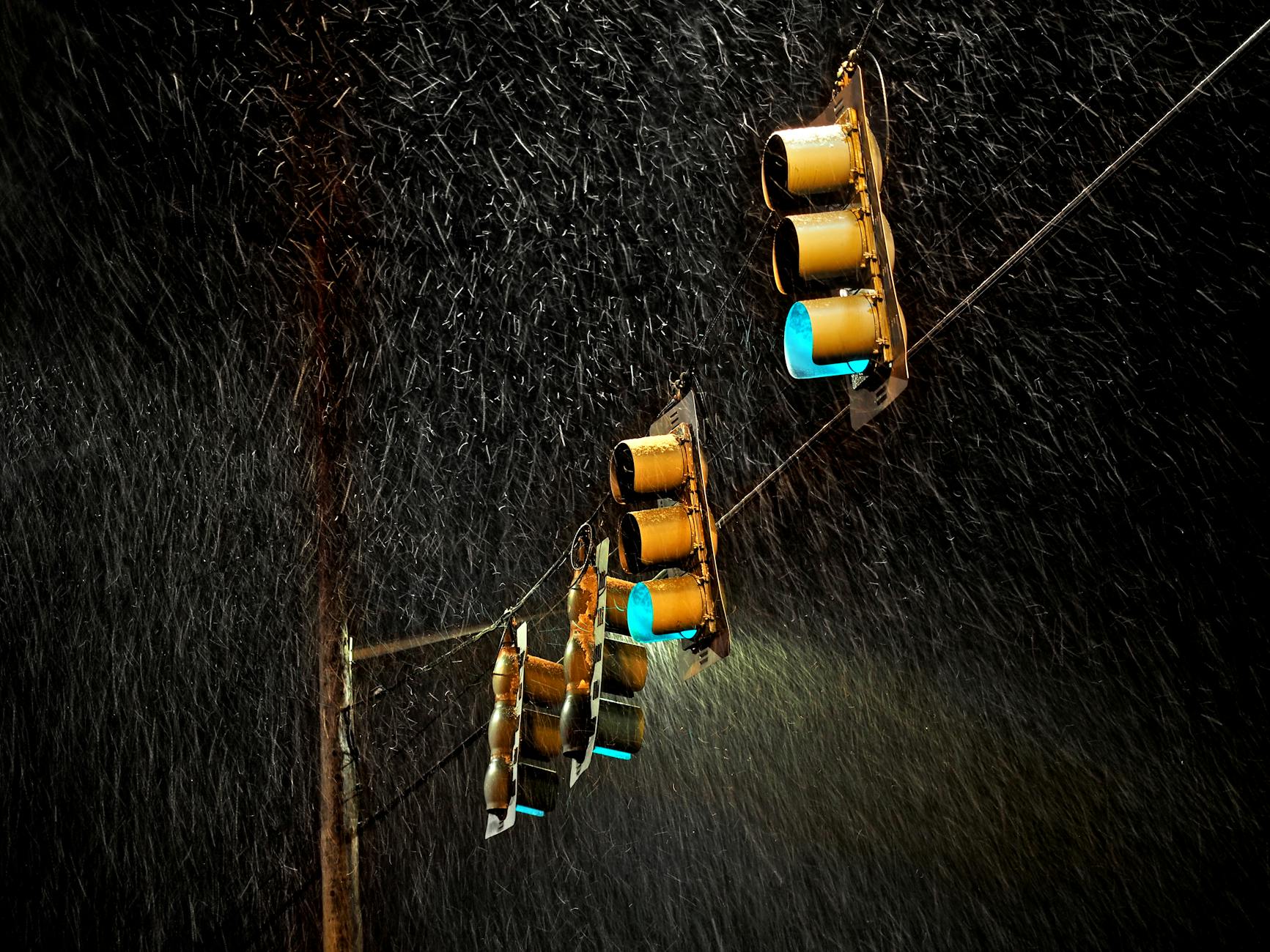 Traffic lights glowing in the rain with a long exposure effect at night.