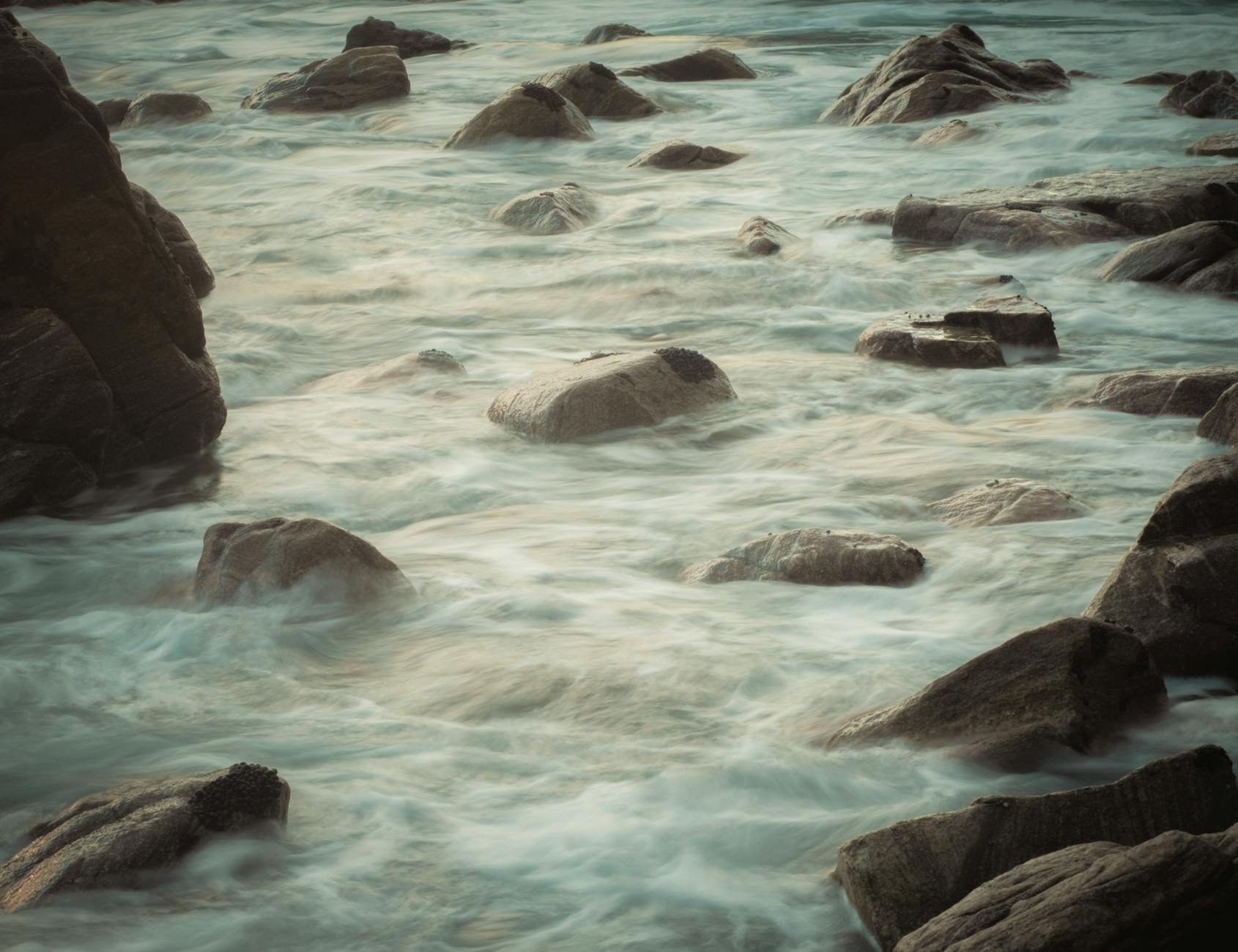 Tranquil image of a rocky coastline with smooth, flowing waves creating a peaceful atmosphere. Tranquil image of a rocky coastline with smooth, flowing waves creating a peaceful atmosphere.
