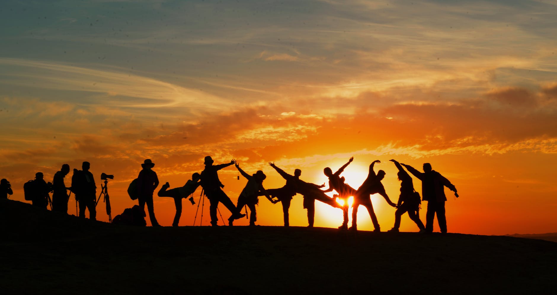 Group of people silhouetted against a vibrant sunset, showcasing unity and joy. Group of people silhouetted against a vibrant sunset, showcasing unity and joy.