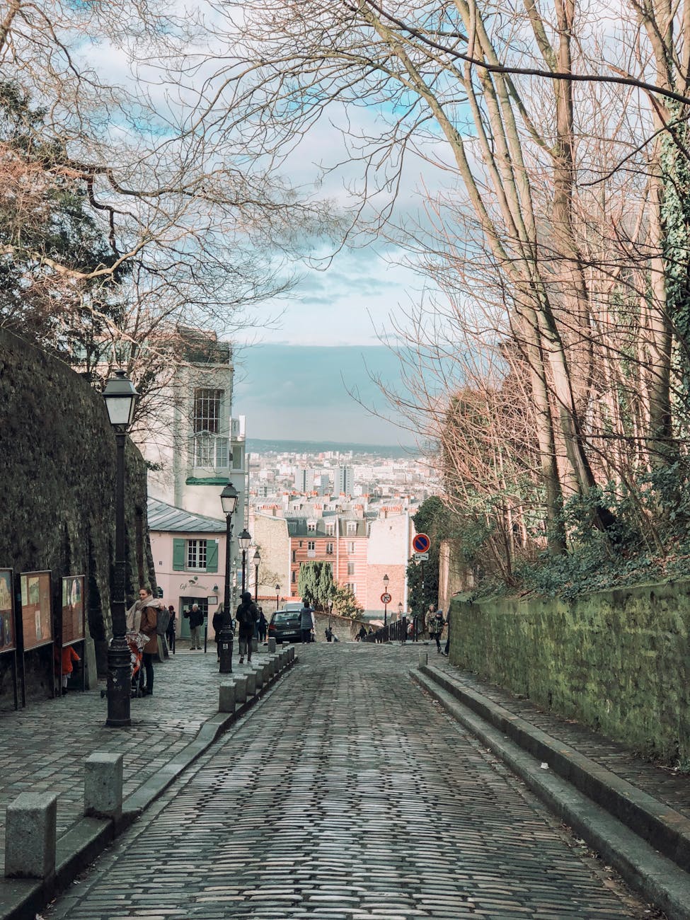 Picturesque cobblestone street in Montmartre with city view, capturing Parisian charm. Picturesque cobblestone street in Montmartre with city view, capturing Parisian charm.