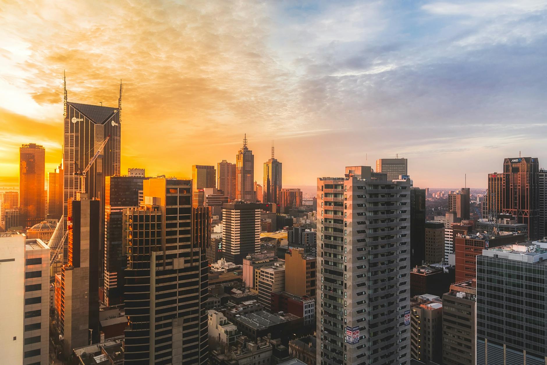 Stunning view of Melbourne’s skyline at sunset, capturing modern skyscrapers and warm sky.