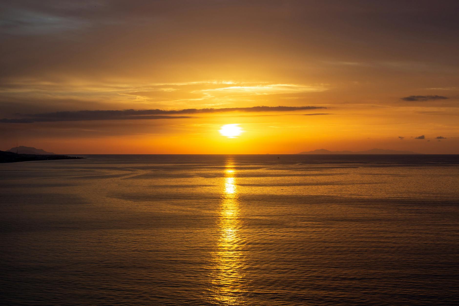 Breathtaking sunset casting golden reflections on the serene ocean waters.