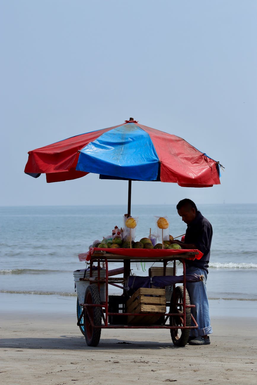 Beach vendor with fruit cart under umbrella on Veracruz shore. Beach vendor with fruit cart under umbrella on Veracruz shore.