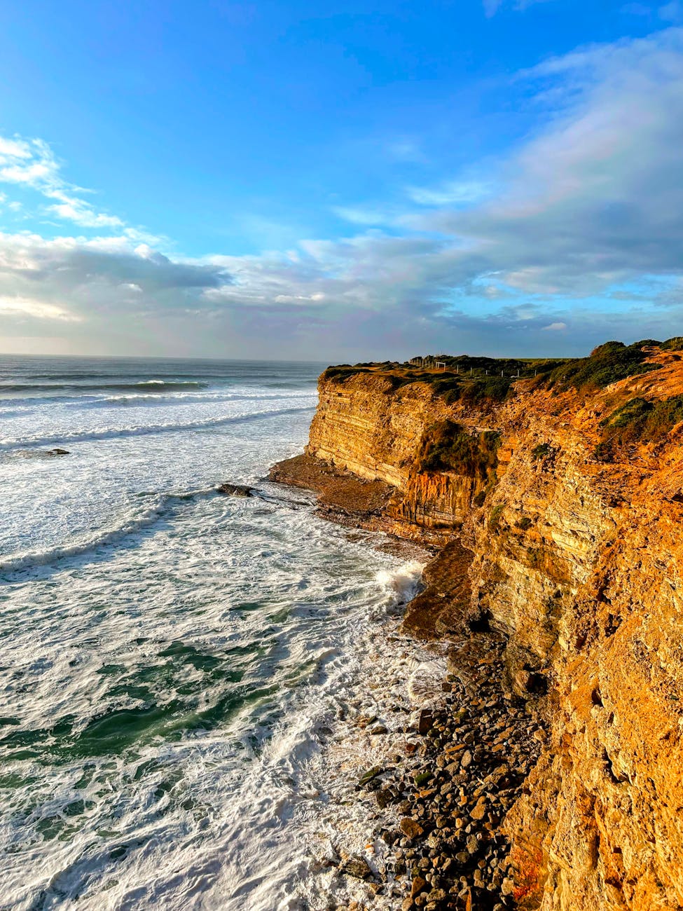 Stunning cliffside waves against a rugged coastline in Portugal at sunset. Stunning cliffside waves against a rugged coastline in Portugal at sunset.