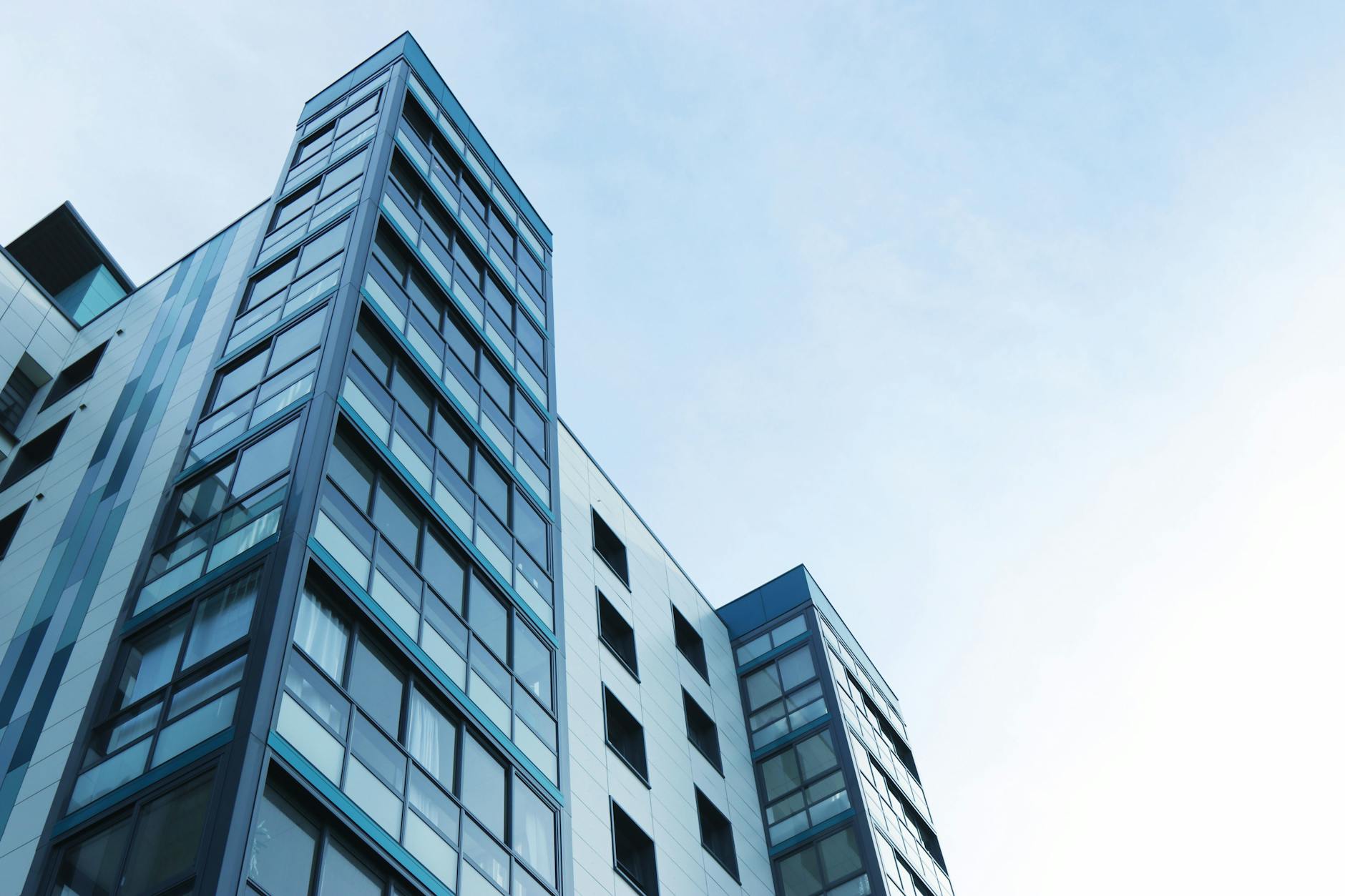 Low-angle view of a modern glass skyscraper against a clear sky in Poole, UK. Low-angle view of a modern glass skyscraper against a clear sky in Poole, UK.