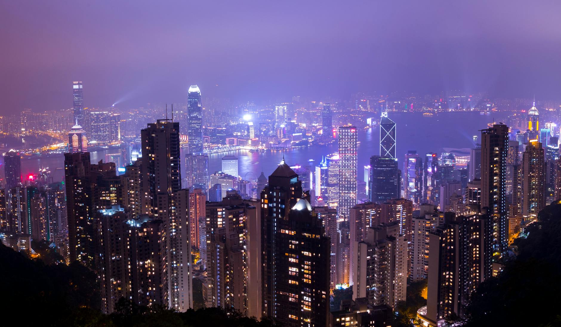 Stunning night view of Hong Kong skyline with illuminated skyscrapers and city lights.