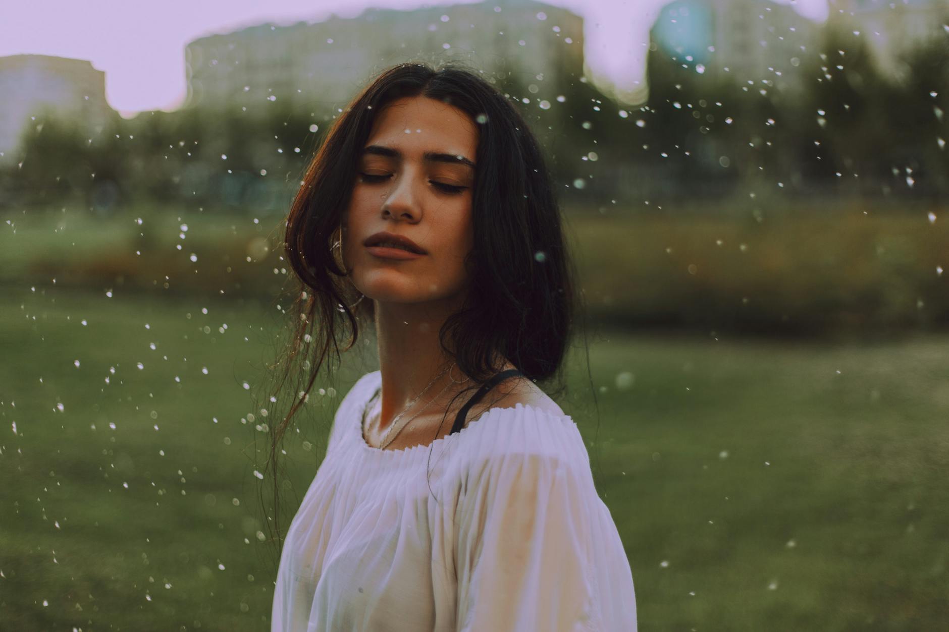 Serene portrait of a young woman enjoying the outdoors, with gentle rain falling. Serene portrait of a young woman enjoying the outdoors, with gentle rain falling.