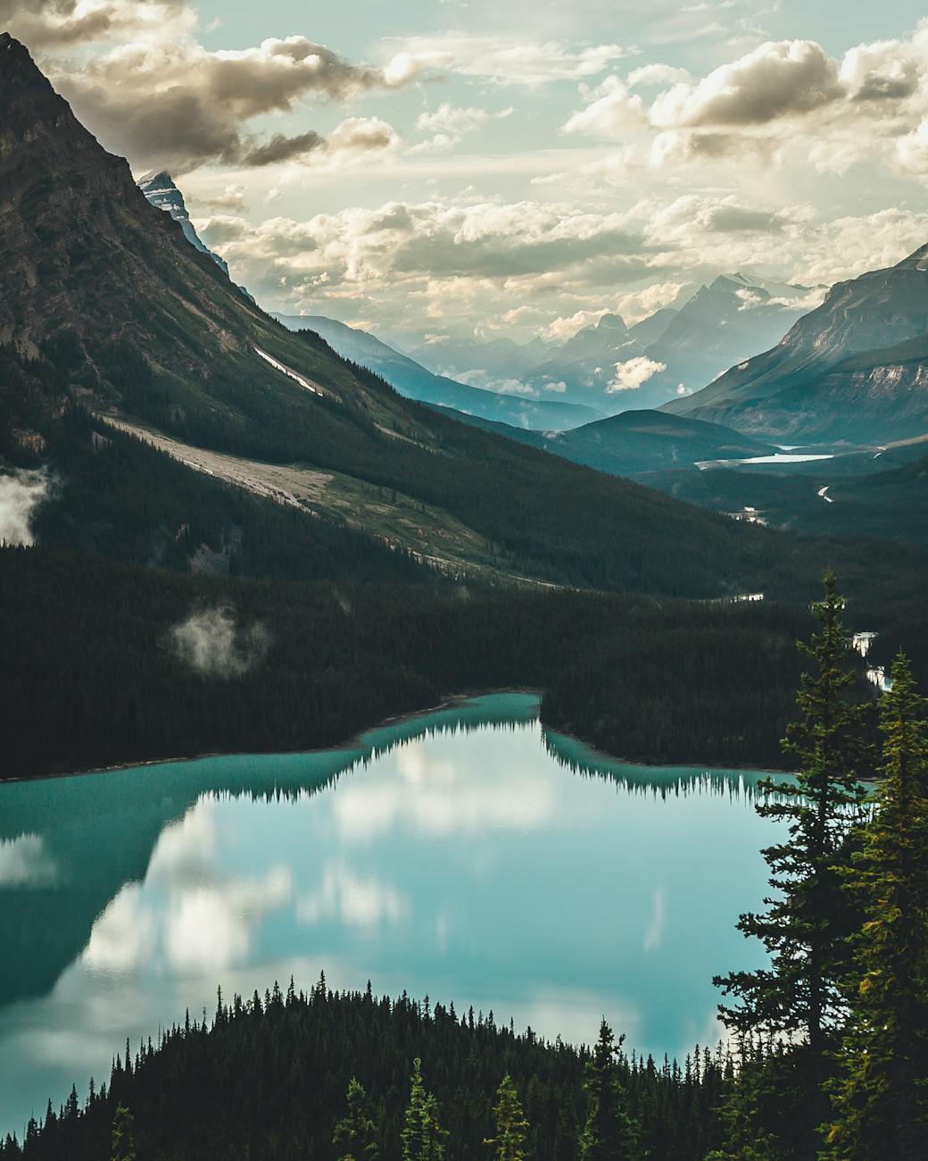 Stunning view of a tranquil lake surrounded by towering mountains in the Canadian Rockies.