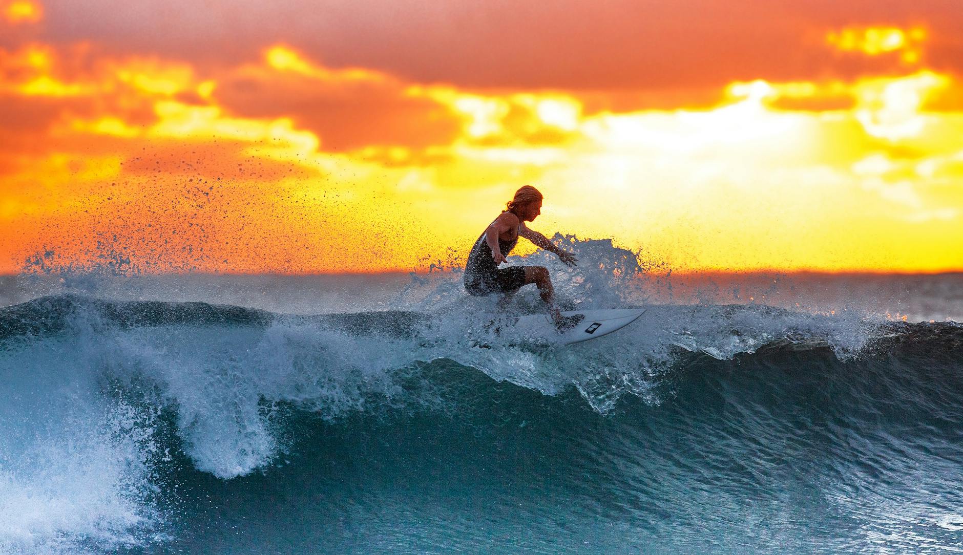Surfer riding a wave during a stunning sunset, capturing the thrill of water sports. Surfer riding a wave during a stunning sunset, capturing the thrill of water sports.
