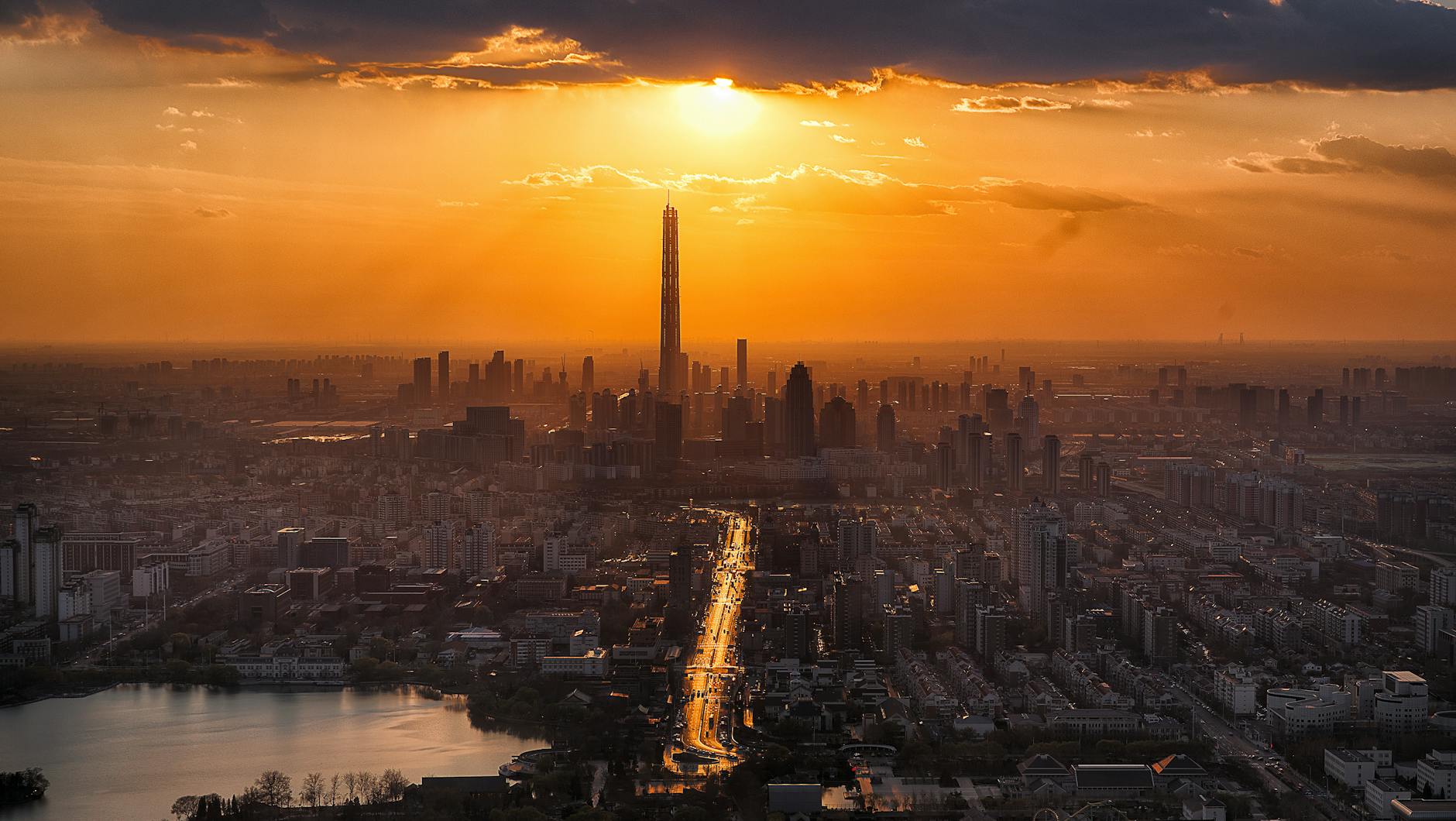 A breathtaking cityscape with tall skyscrapers silhouetted against a golden sunset.