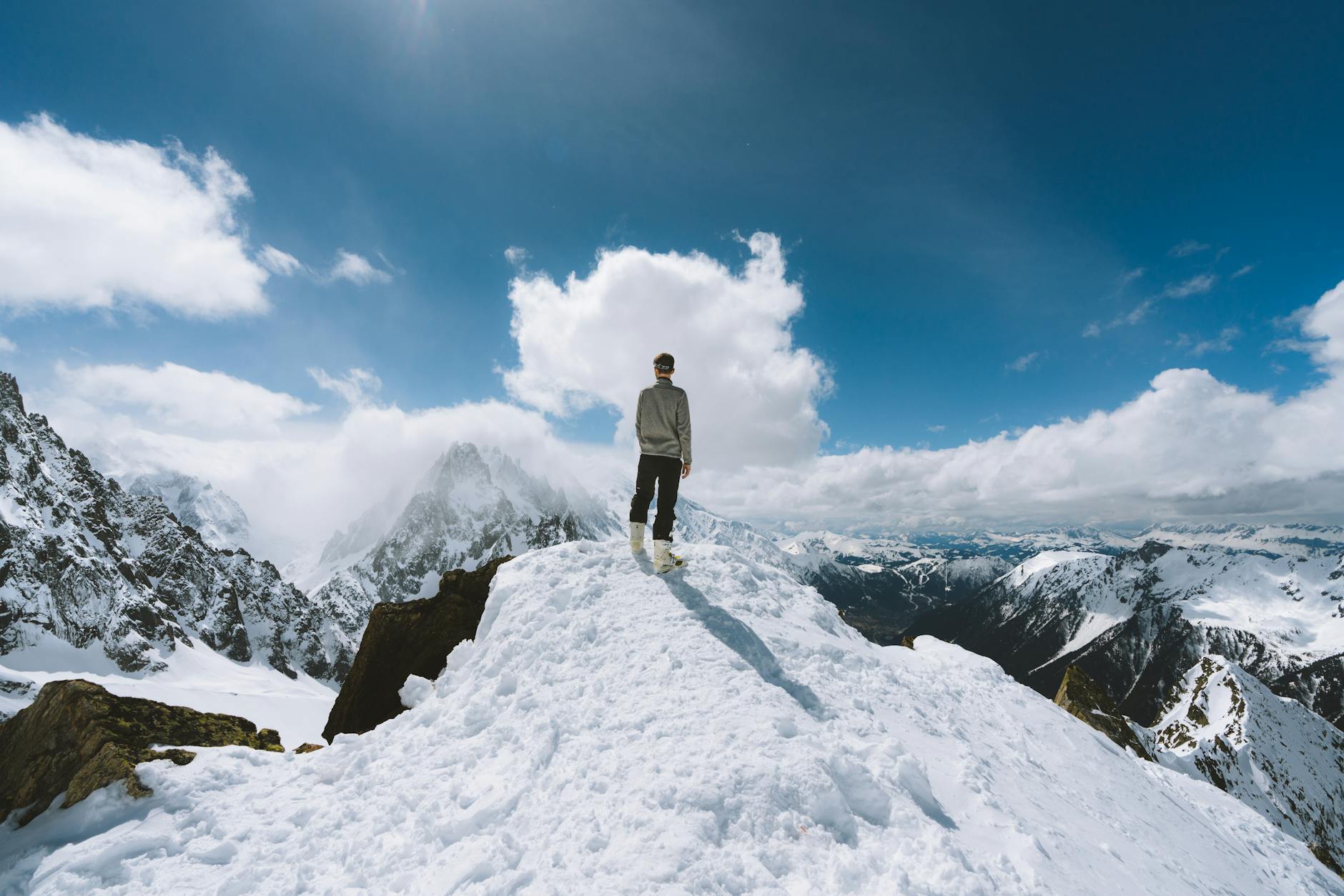 Person standing on a snow-covered peak in Chamonix-Mont-Blanc, France, showcasing a breathtaking mountain view. Person standing on a snow-covered peak in Chamonix-Mont-Blanc, France, showcasing a breathtaking mountain view.