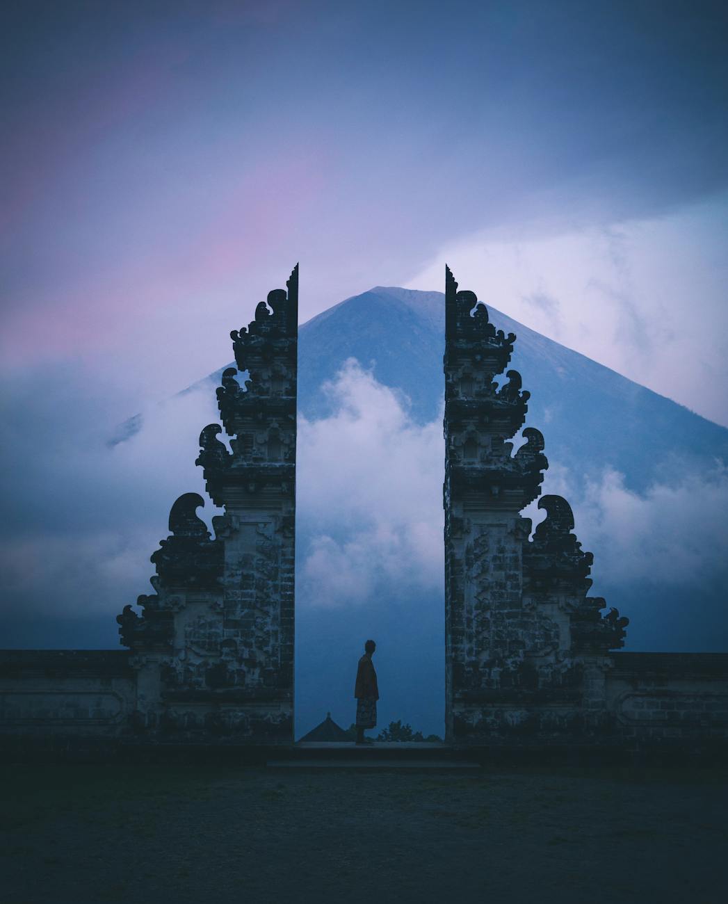 Silhouette at Pura Lempuyang Temple in Bali with Mount Agung in the background at twilight.