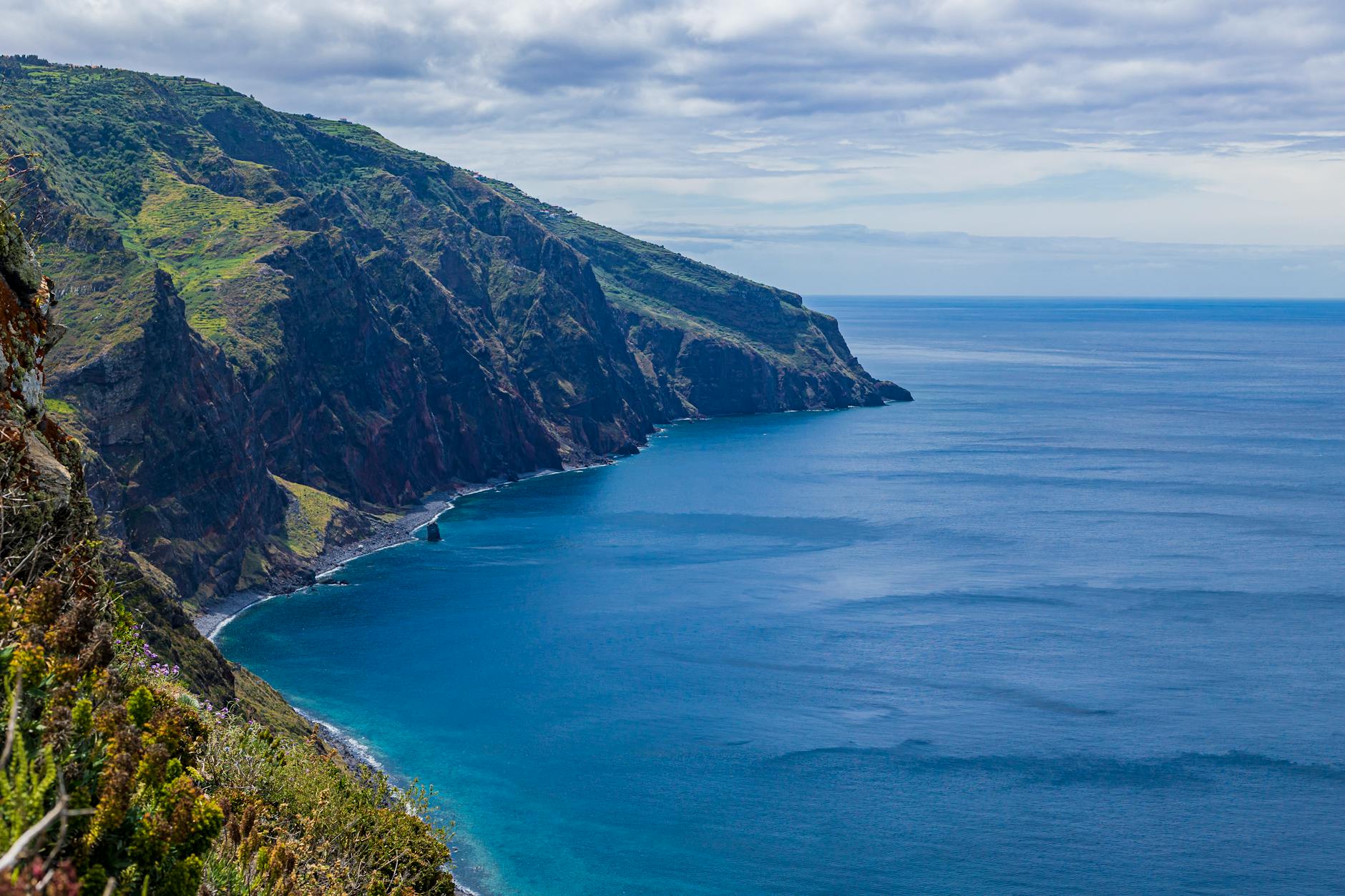 Breathtaking view of Madeira Island’s rugged cliffs and blue ocean waters, a travel highlight.