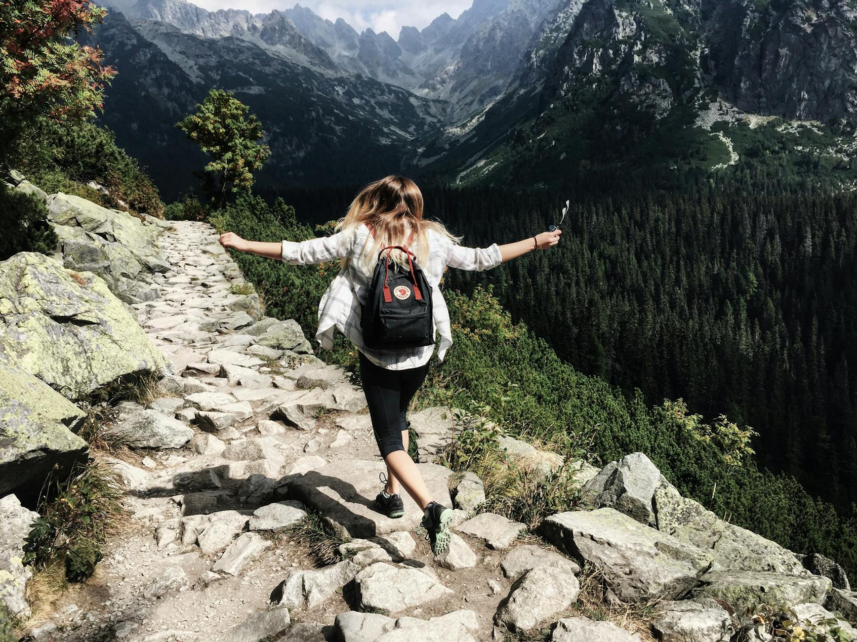 Woman hikes along rocky path in Vysoké Tatry, Slovakia. Embracing nature and freedom. Woman hikes along rocky path in Vysoké Tatry, Slovakia. Embracing nature and freedom.