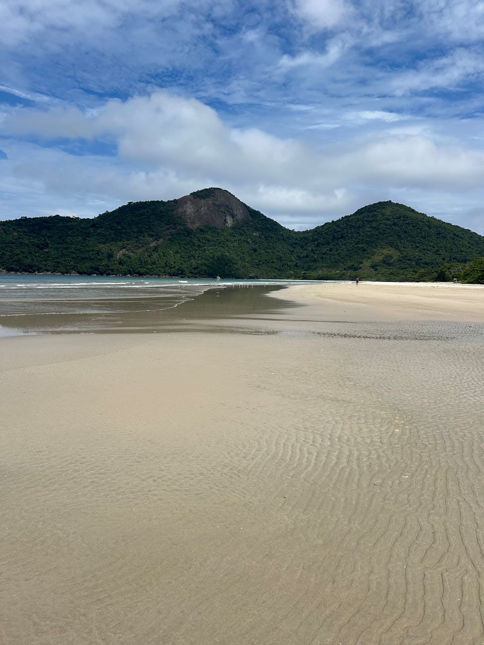 A peaceful beach with golden sands and green hills under a vibrant sky. A peaceful beach with golden sands and green hills under a vibrant sky.