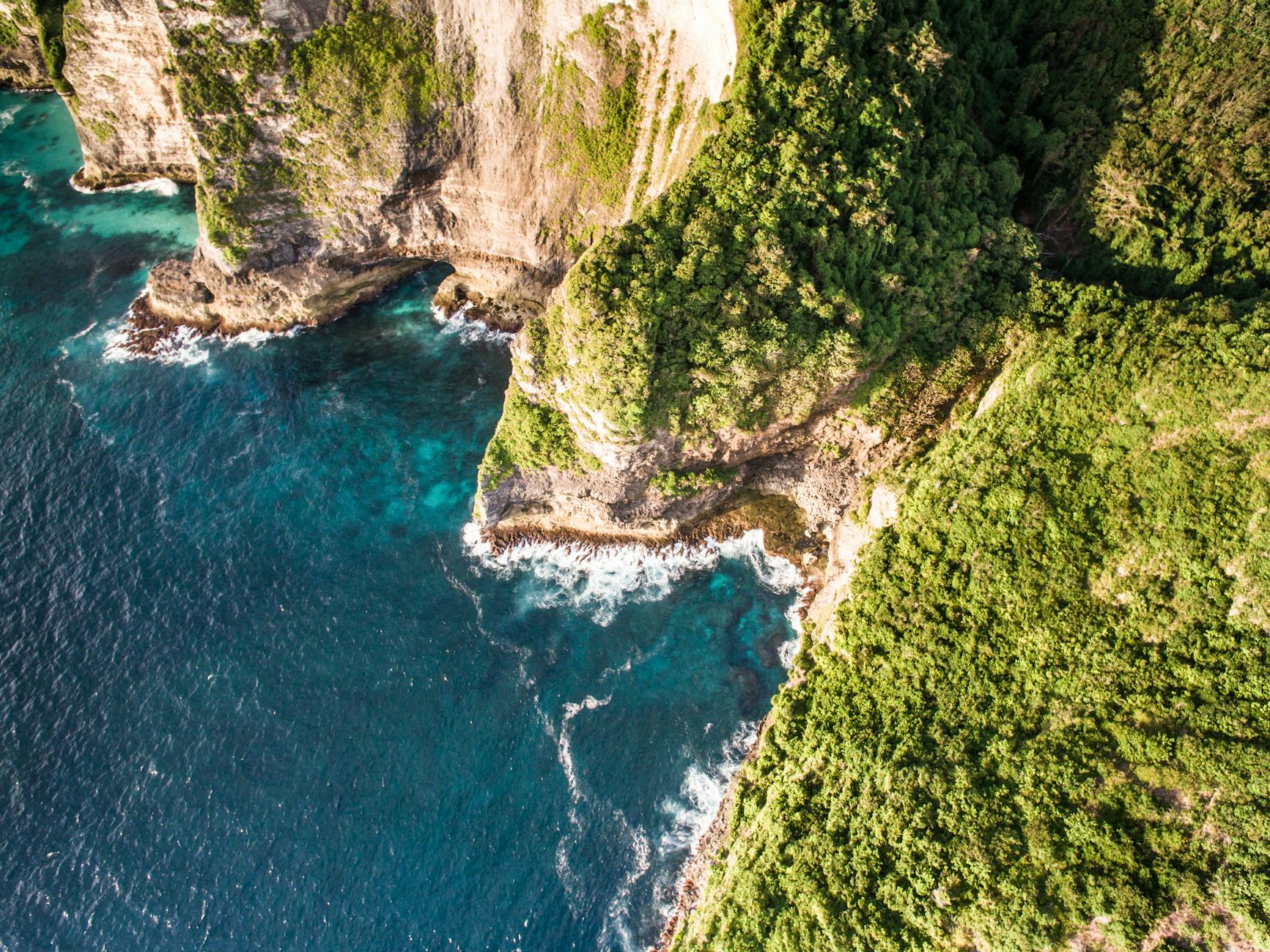 Dramatic aerial capture of rocky cliffs meeting the ocean, highlighting nature’s rugged beauty. Dramatic aerial capture of rocky cliffs meeting the ocean, highlighting nature’s rugged beauty.