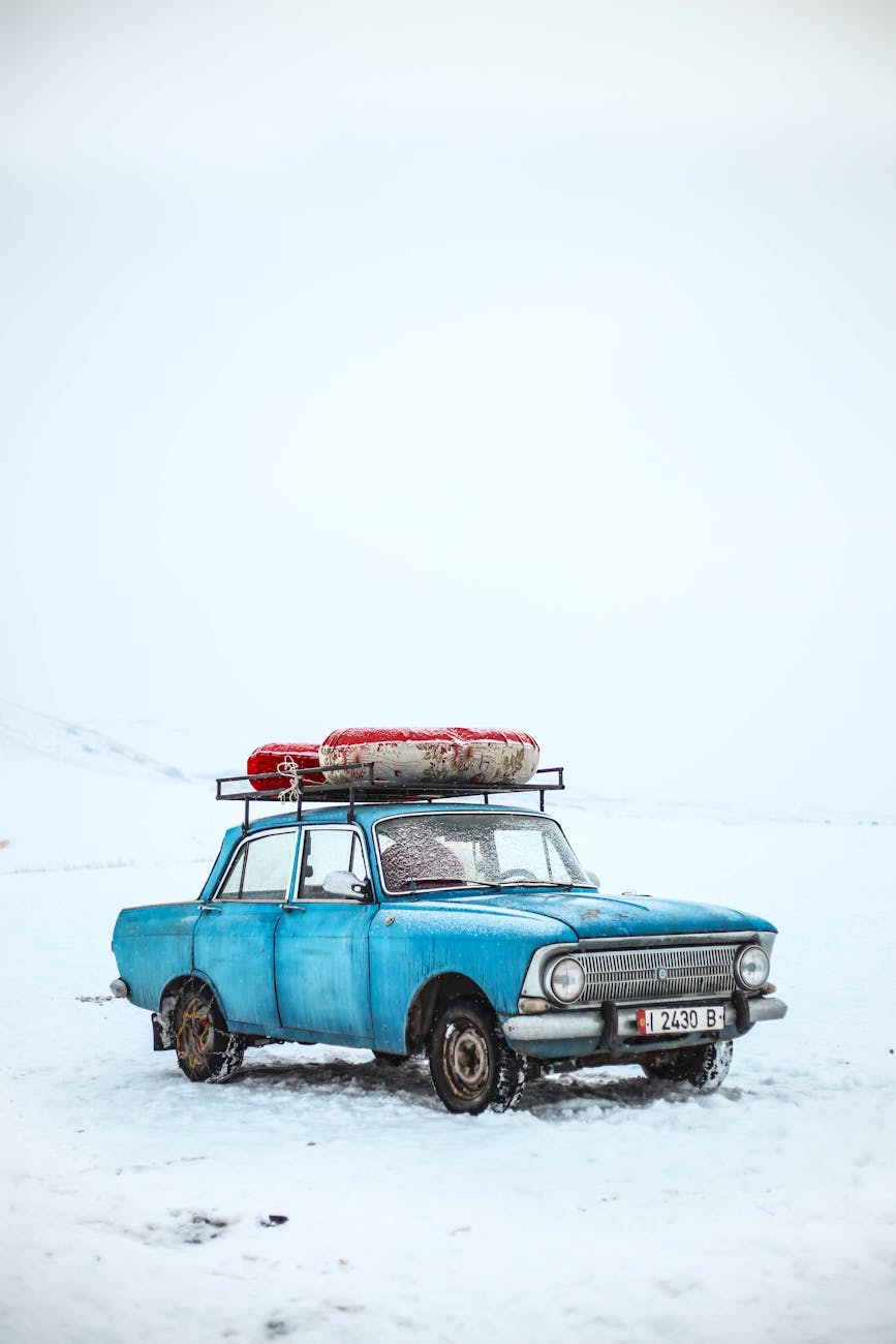 Classic blue car in snowy winter scene, Ak-Talaa District, Kyrgyzstan. Classic blue car in snowy winter scene, Ak-Talaa District, Kyrgyzstan.