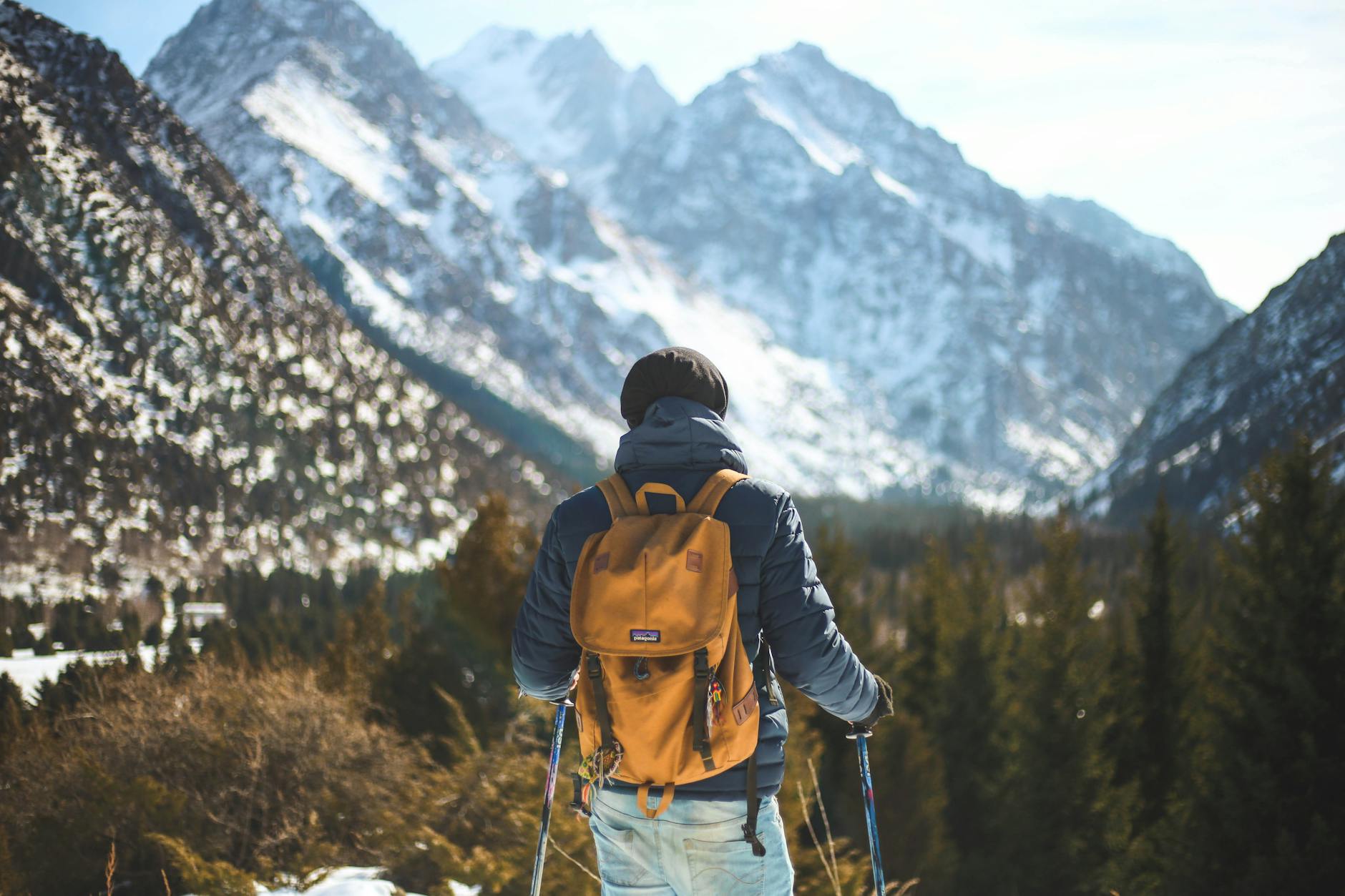A lone hiker with a backpack explores a scenic winter mountain landscape. A lone hiker with a backpack explores a scenic winter mountain landscape.