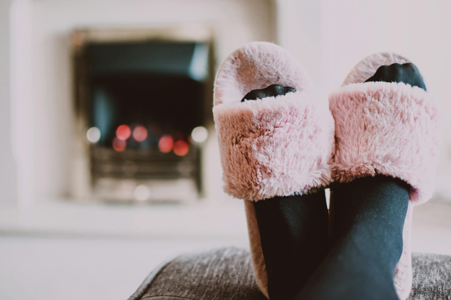 Relaxing by the fireplace with fuzzy slippers and warm socks indoors.