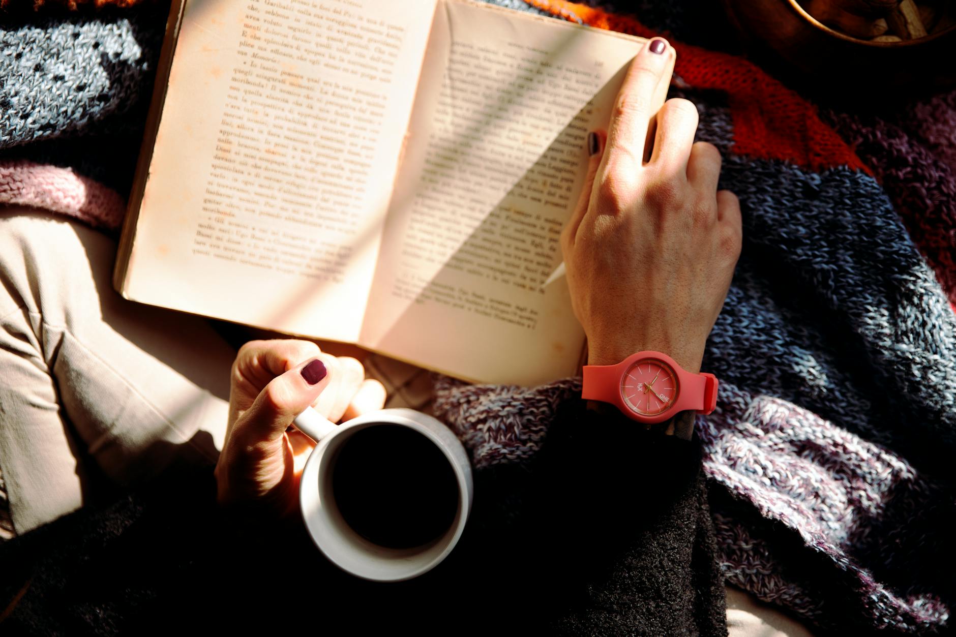 Woman relaxing with a book and coffee in a sunlit cozy setting, wearing a stylish watch. Woman relaxing with a book and coffee in a sunlit cozy setting, wearing a stylish watch.