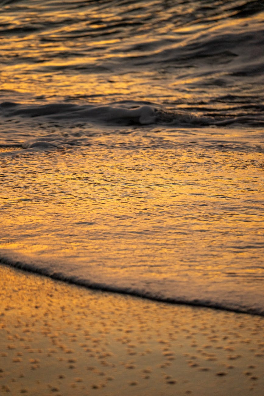 Waves gently lapping the golden-lit shores of Nerja. Captured at sunset, Andalucía.