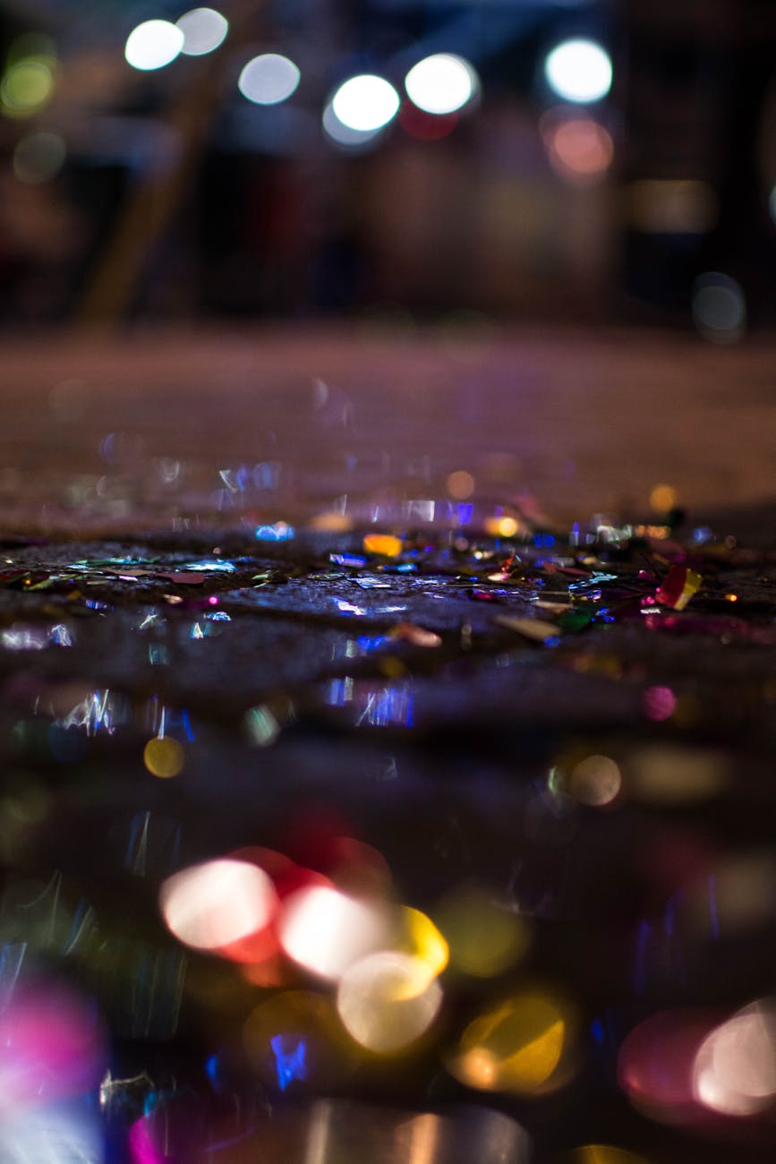 Colorful confetti sparkling in low light on a wet street in Rethymno, Greece.
