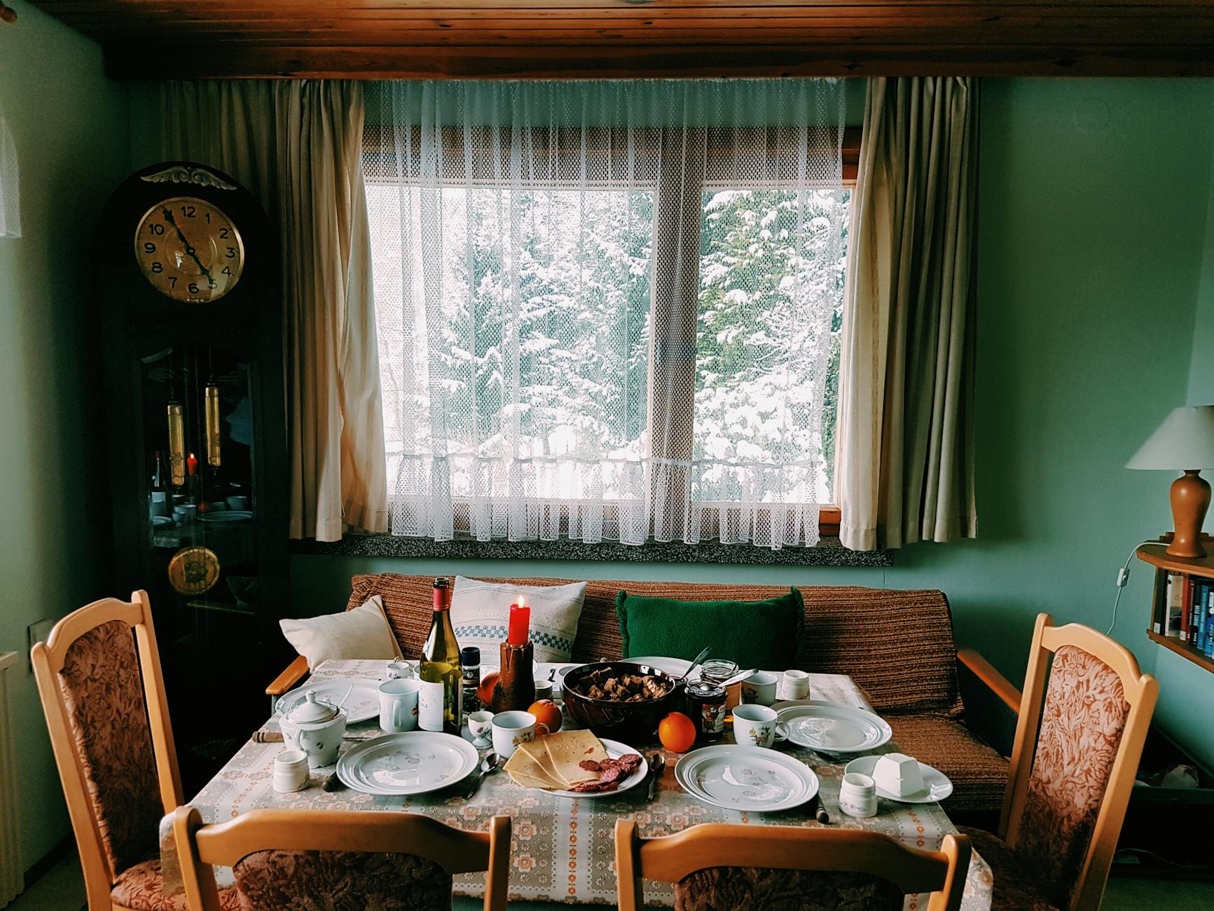 Warm and inviting dining room set for a festive meal, with a snowy view outside. Warm and inviting dining room set for a festive meal, with a snowy view outside.