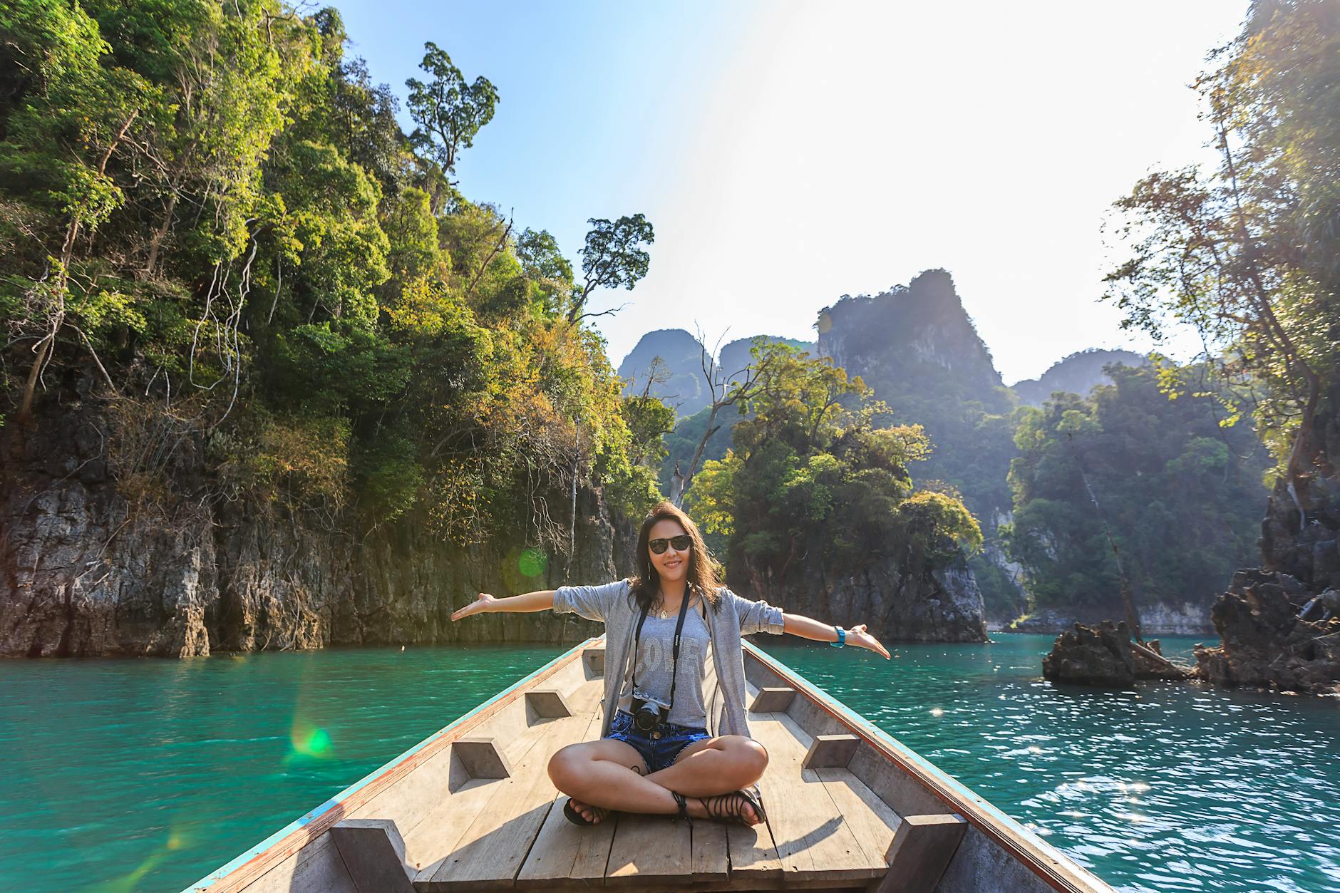 Asian woman relishing a serene boat journey through the lush karst landscape of Thailand’s Khlong Sok. Asian woman relishing a serene boat journey through the lush karst landscape of Thailand’s Khlong Sok.