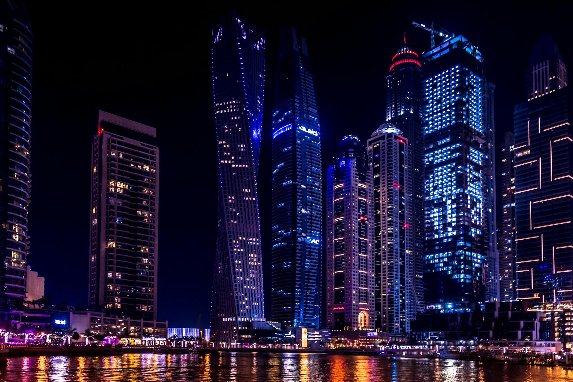 Illuminated skyscrapers of Dubai Marina at night, reflecting on the water. Illuminated skyscrapers of Dubai Marina at night, reflecting on the water.
