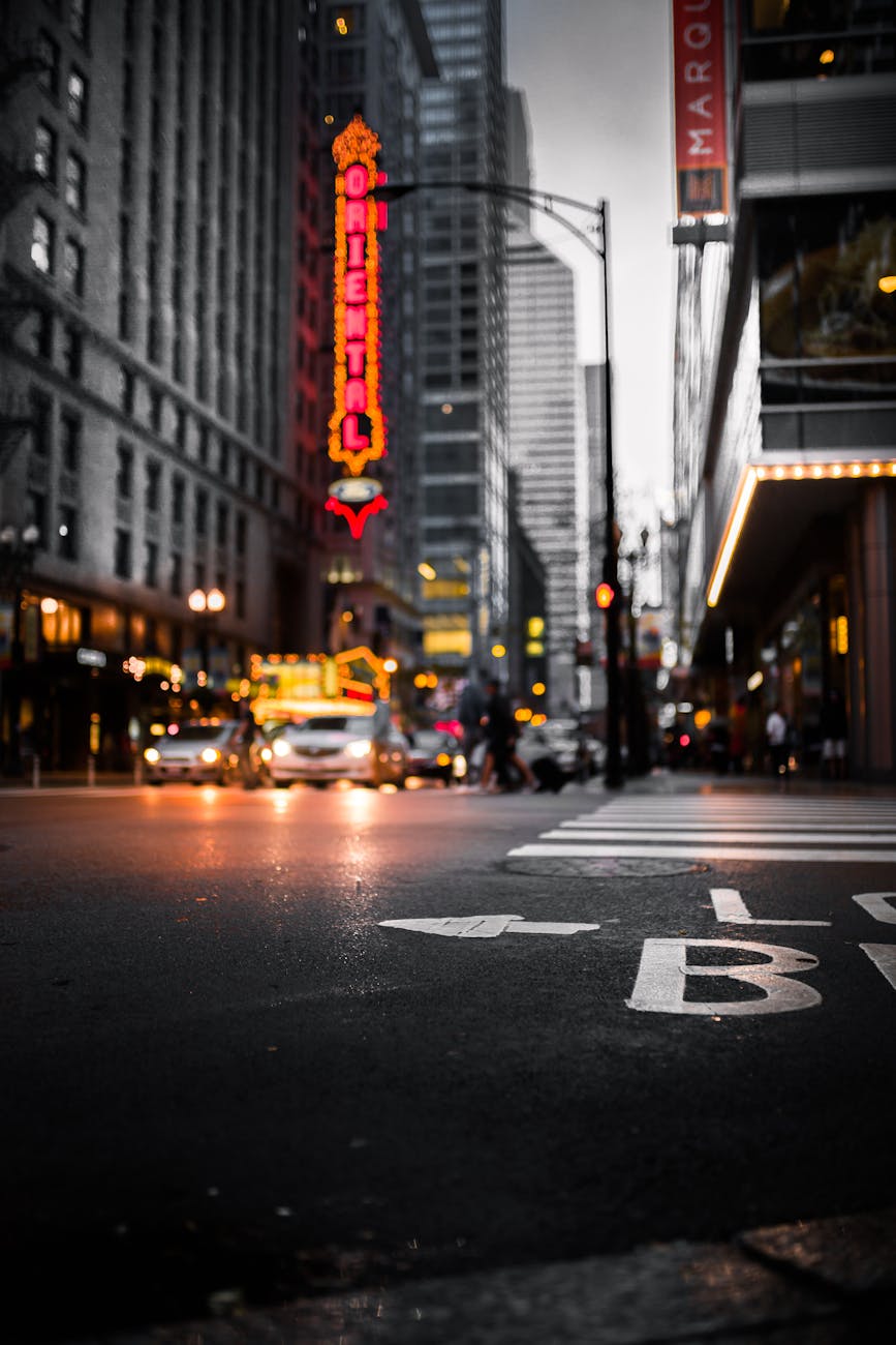 Dynamic cityscape at night with illuminated signs, streetlights, and a bustling intersection.