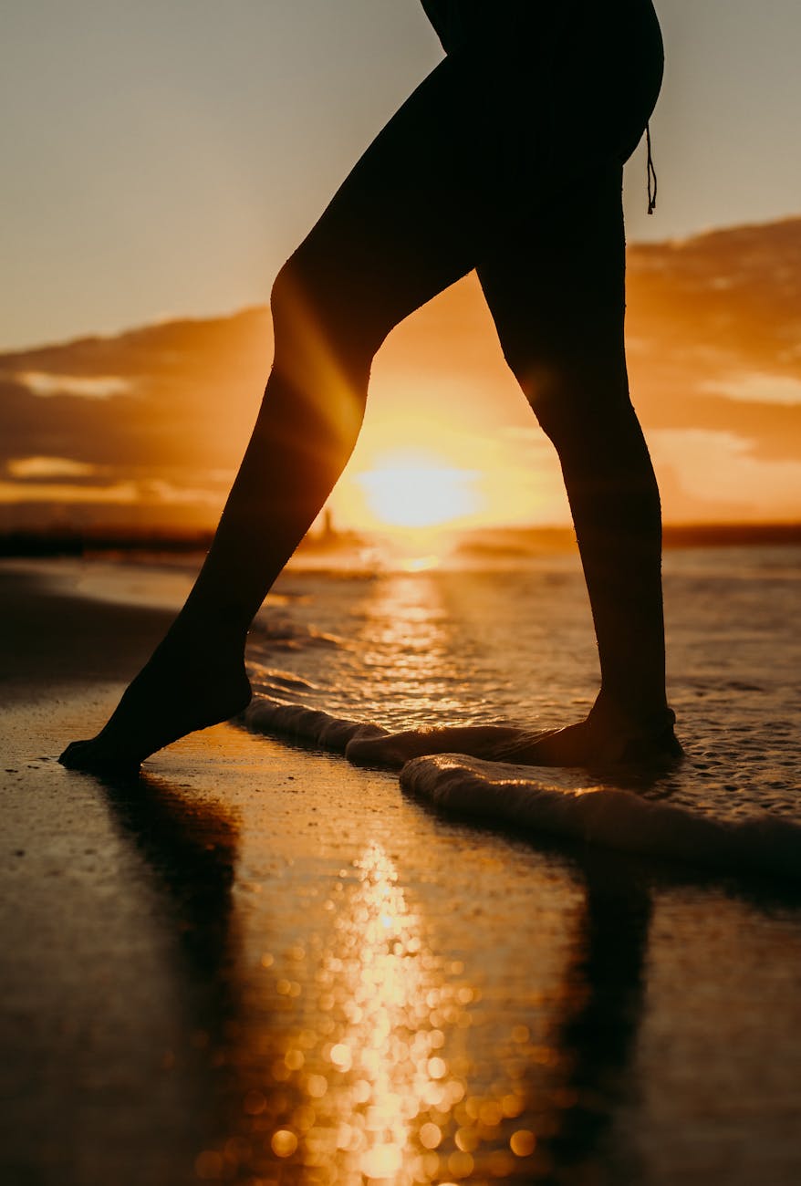 A captivating silhouette of a woman standing at the beach during a stunning sunset. A captivating silhouette of a woman standing at the beach during a stunning sunset.