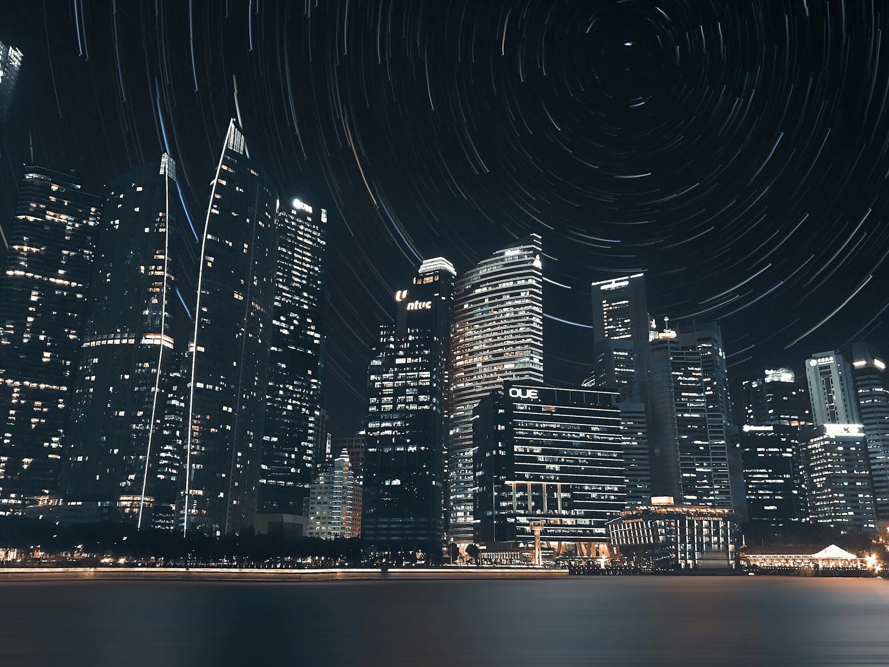 Stunning long exposure of Singapore’s night skyline, highlighting skyscrapers and star trails. Stunning long exposure of Singapore’s night skyline, highlighting skyscrapers and star trails.