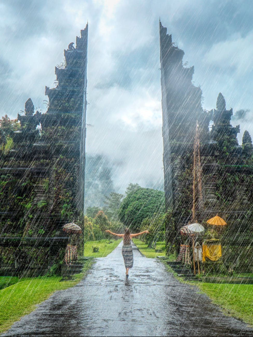 Woman in vibrant rain at iconic Handara Gate, Bali. A magical travel moment. Woman in vibrant rain at iconic Handara Gate, Bali. A magical travel moment.